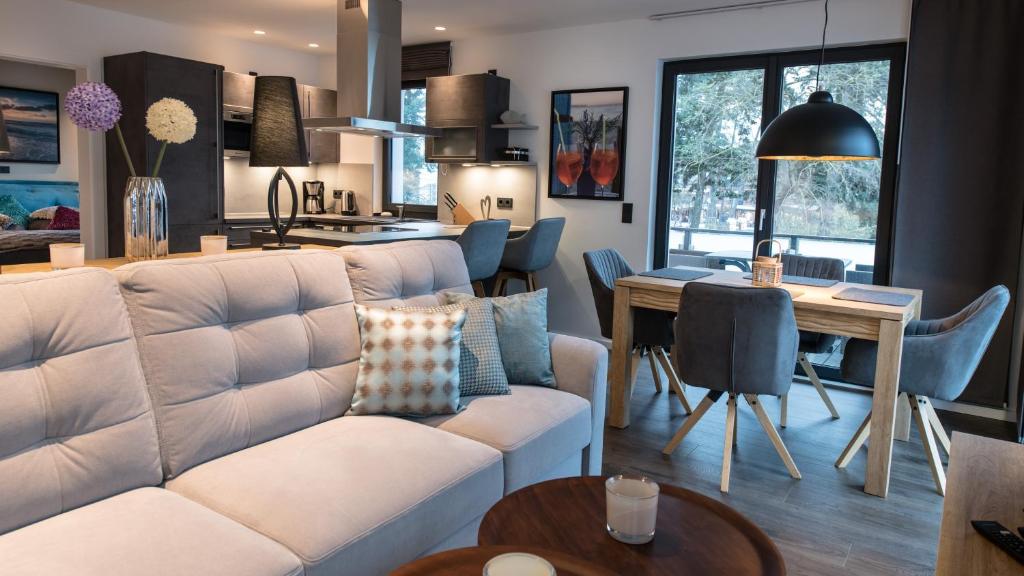 - un salon avec un canapé blanc et une table dans l'établissement Ocean House Herz, à Timmendorfer Strand