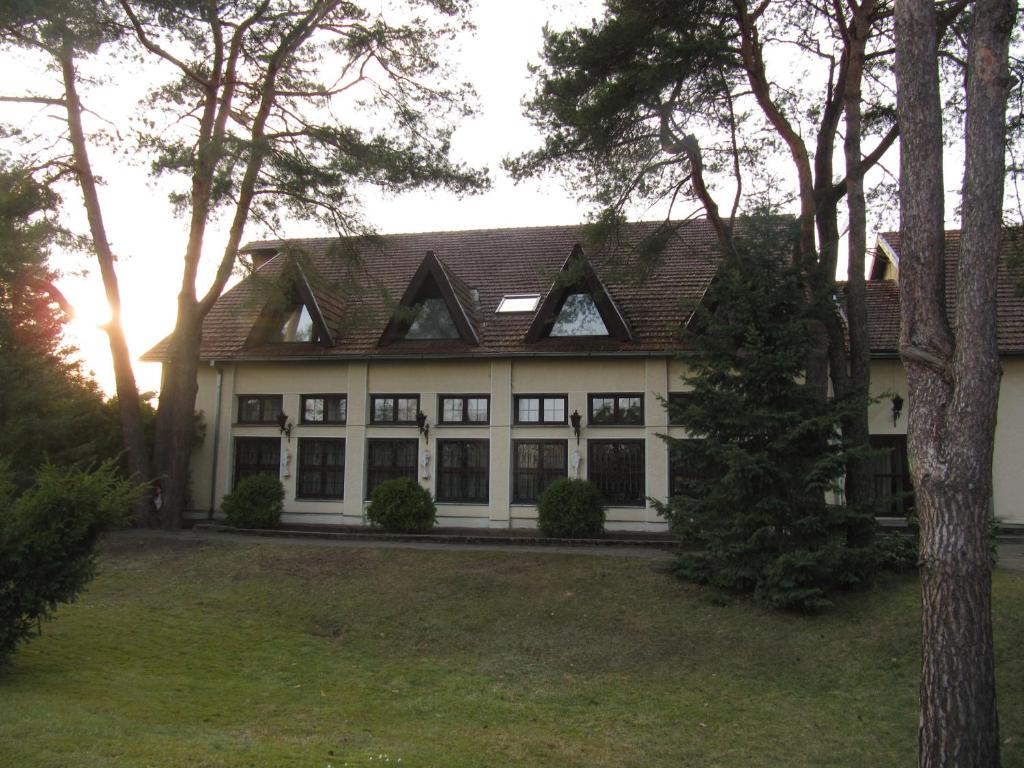 a large white house with a brown roof at Apartamentai Lampėdžiuose in Kaunas