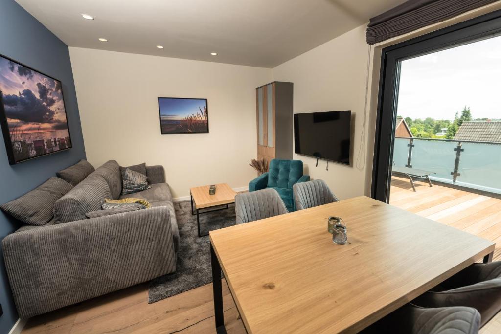 ein Wohnzimmer mit einem Sofa und einem Tisch in der Unterkunft Heaven House Penthousewohnung Sterngucker mit Whirlpool in Timmendorfer Strand