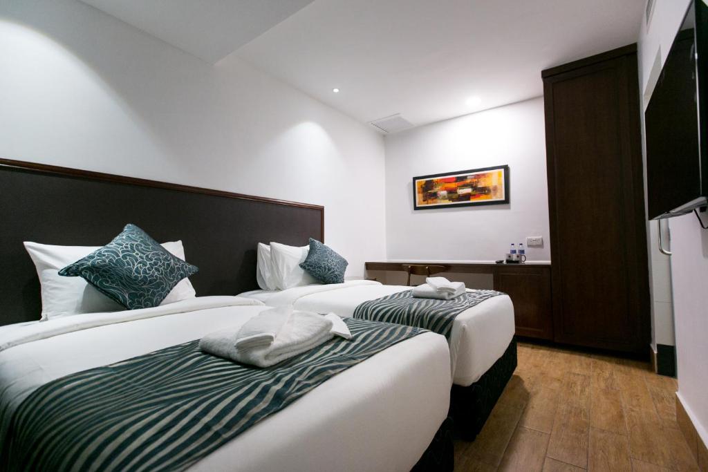 Postel nebo postele na pokoji v ubytování Belllo Hotel JB Central