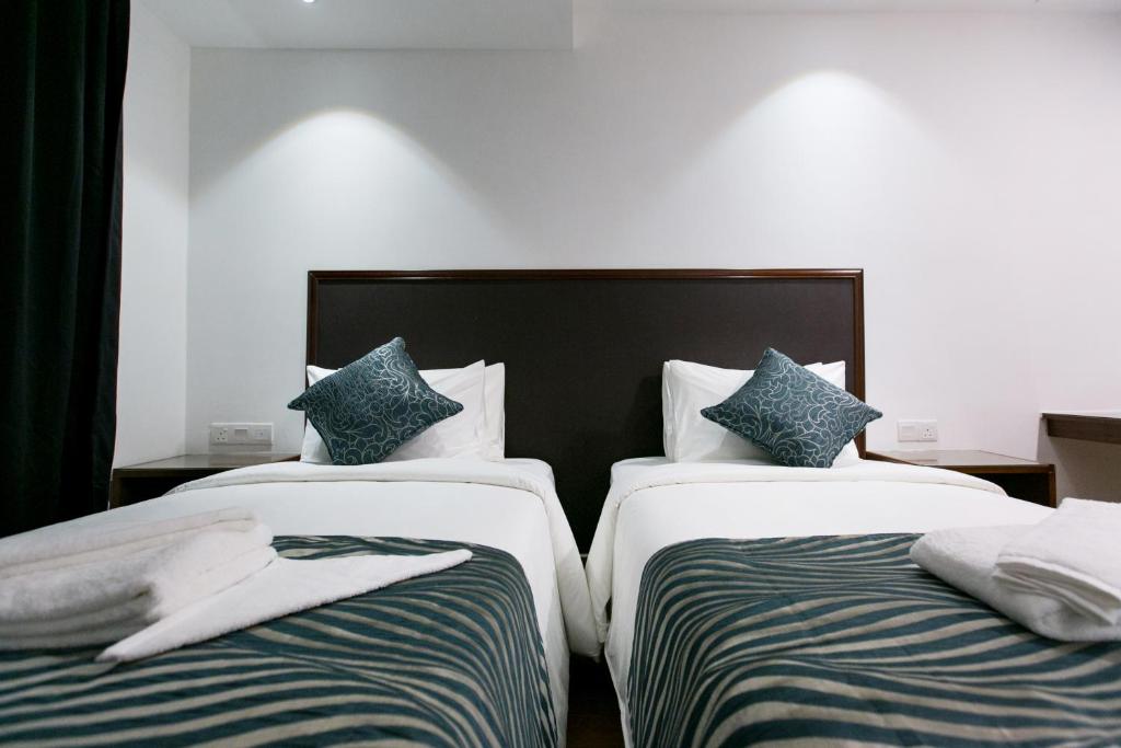 Postel nebo postele na pokoji v ubytování Belllo Hotel JB Central