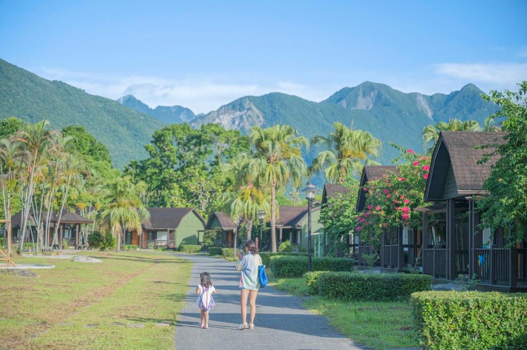 Una mujer y una niña caminando por una calle en Chu Resort Hualien en Fenglin