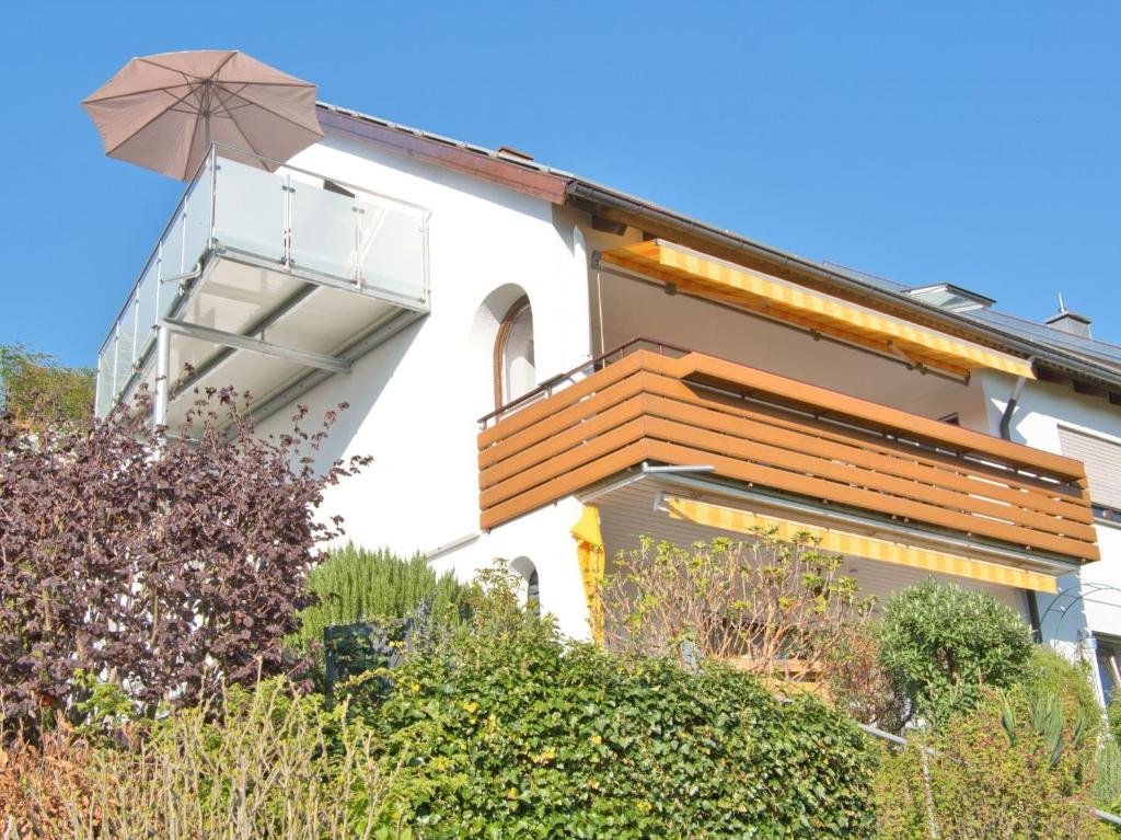 Cette maison dispose d'un balcon avec un parasol. dans l'établissement Ferienhaus Stäffele, à Überlingen