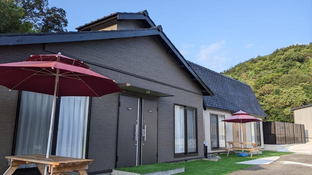 a house with a picnic table and an umbrella at 関空国際ホテル in Wakayama