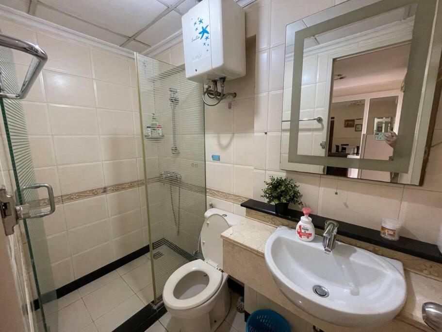 ein Badezimmer mit einem Waschbecken, einem WC und einem Spiegel in der Unterkunft 2 bedroom next to Mall Central Park & Neo Soho (Medit 1) in Jakarta
