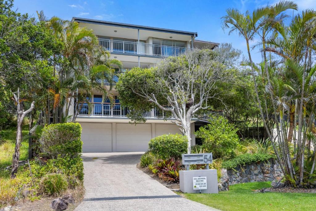 a house with a garage and palm trees at Kings View in Peregian Beach