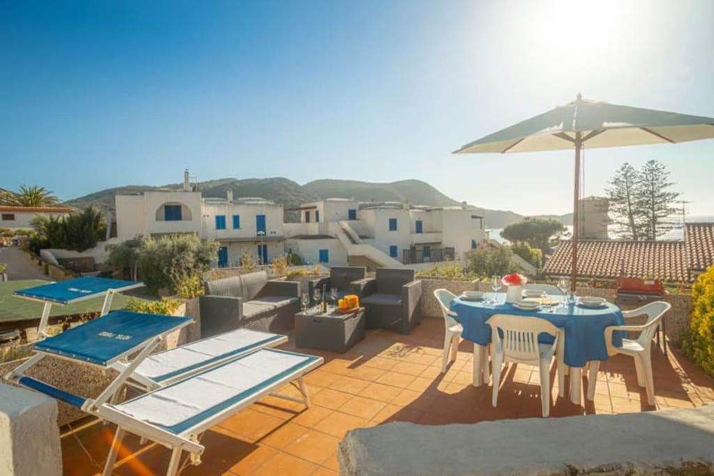 a patio with a table and chairs and an umbrella at Isolella in Campese