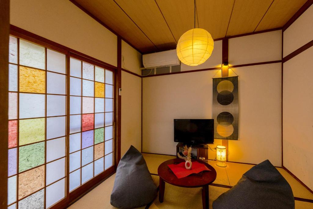 Una habitación con dos sillas y una mesa y un televisor. en 【天神HOUSE 】一軒家まるまる貸切, en Fukuoka
