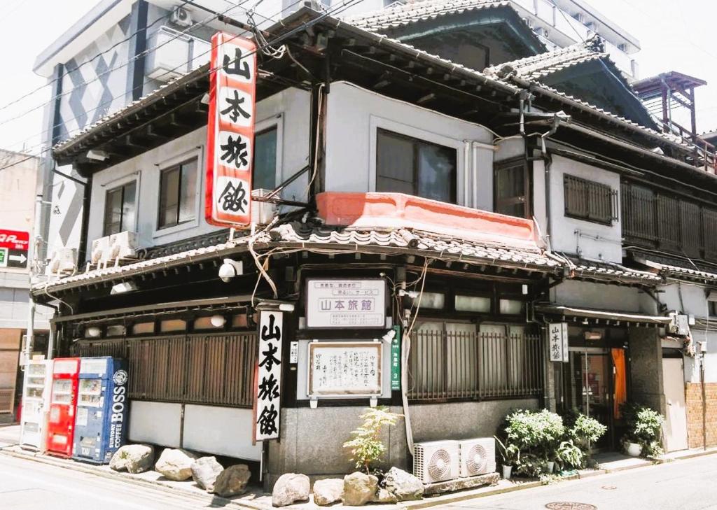 un edificio con dei cartelli sulla parte anteriore di Yamamoto Ryokan a Fukuoka