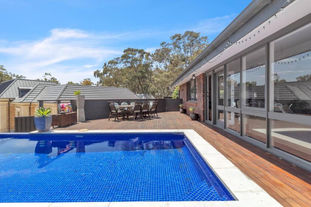 a swimming pool in front of a house at Nature's Edge - A Parkland Escape for Families in Adelaide