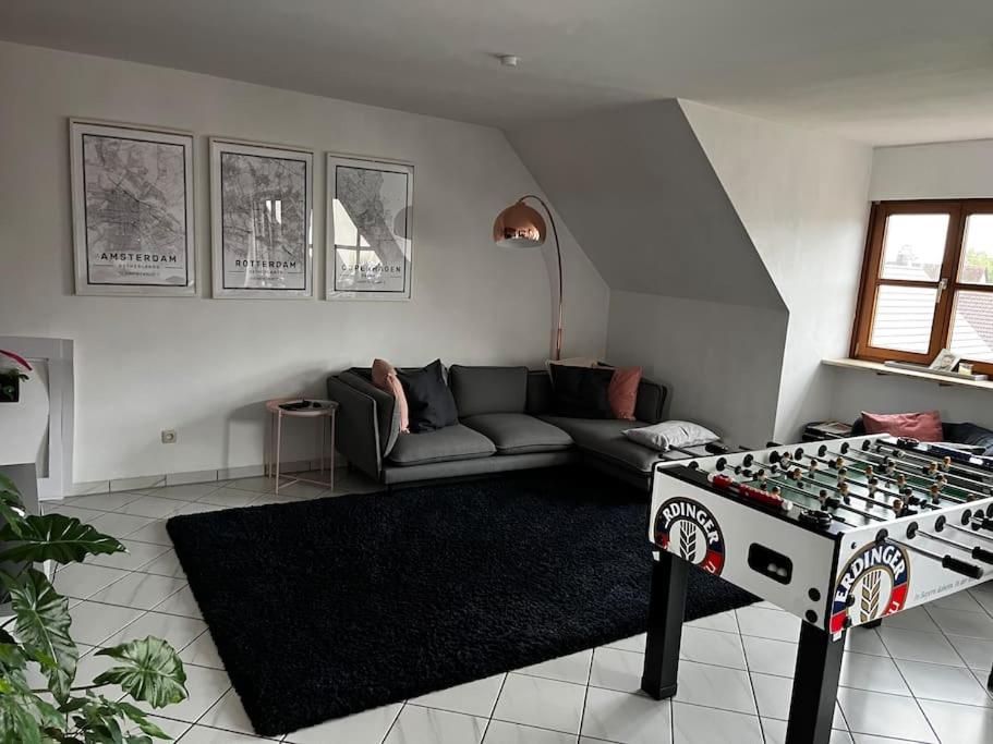 uma sala de estar com um tabuleiro de xadrez no meio de uma sala em Cozy&spacious topfloor apartment em Schwaig bei Nürnberg