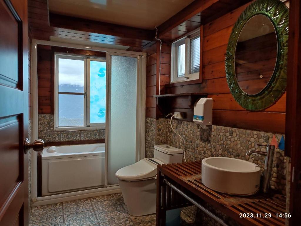 a bathroom with a toilet and a sink and a mirror at Shiyai Taoyuan in Ren&#39;ai