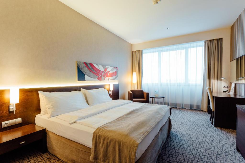 a hotel room with a large bed and a desk at Holiday Inn Zilina, an IHG Hotel in Žilina