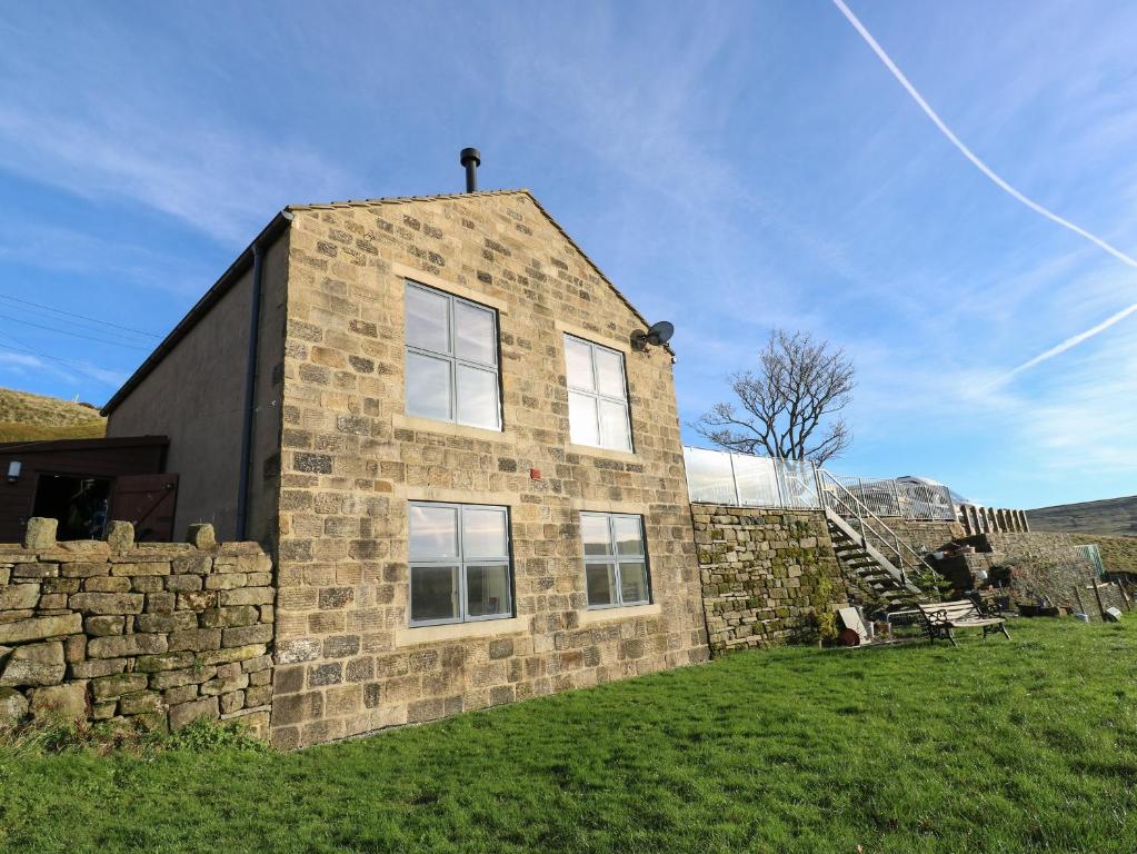 a stone house with a stone wall and a staircase at New Heights in Keighley