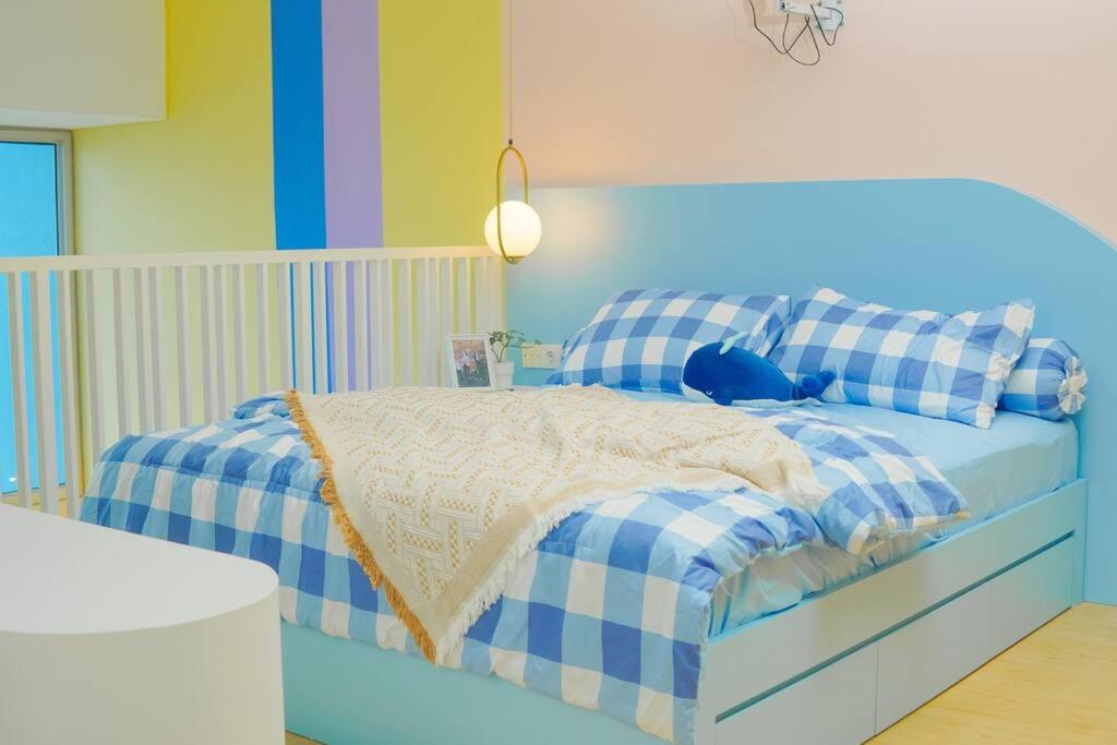 Schlafzimmer mit einem Bett mit blauer und weißer Bettwäsche in der Unterkunft Army’s Nest ~ Sarang army KPOP Style Studio Loft in Jakarta
