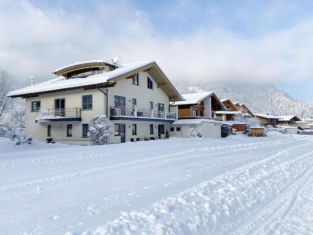 a house in the snow with a snow covered road at Appart Ambiente in Zell am Ziller