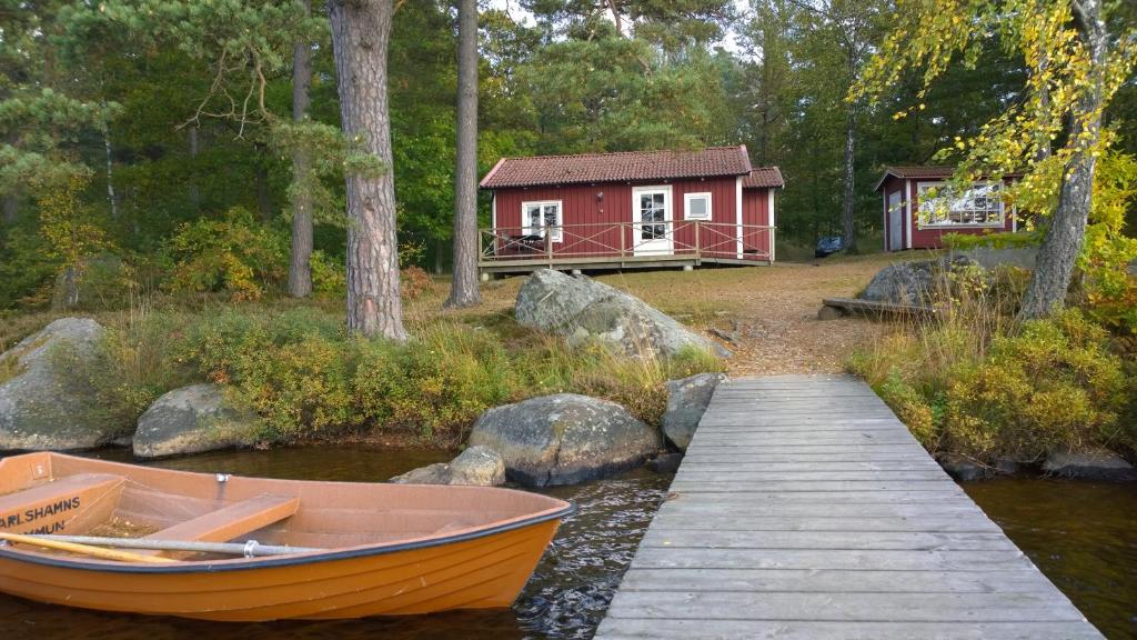 a boat on the water in front of a cabin at Långasjönäs Camping & Stugby in Karlshamn