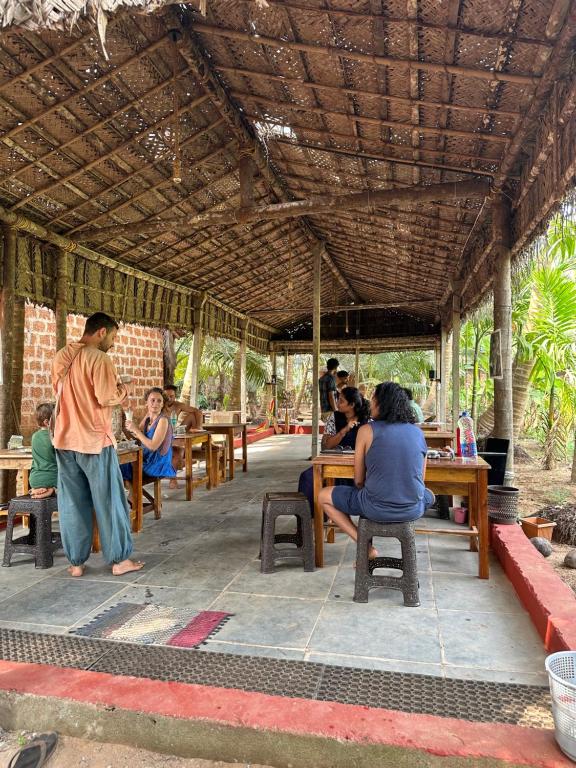 un groupe de personnes assises à table dans un restaurant dans l'établissement HostelExp, Gokarna - A Slow-Paced Backpackers Community, à Gokarna