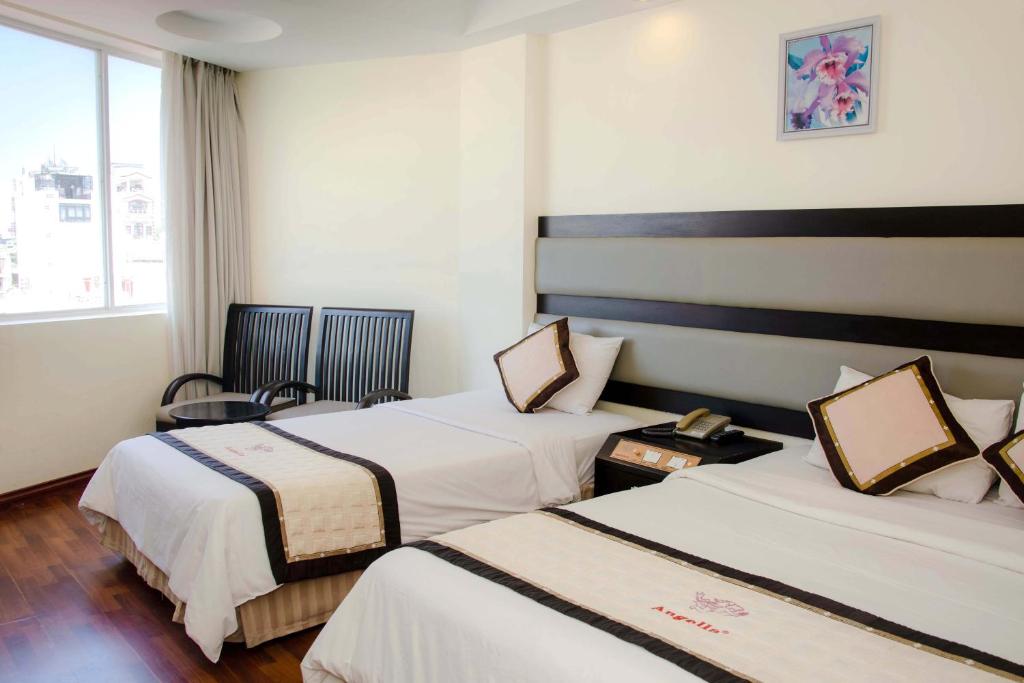 Postel nebo postele na pokoji v ubytování Angella Hotel