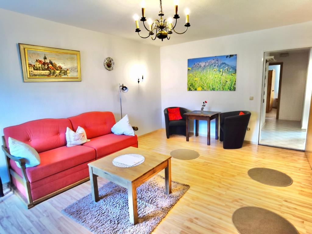een woonkamer met een rode bank en een tafel bij Sparfuchs-Fewo Flori in Mittenwald