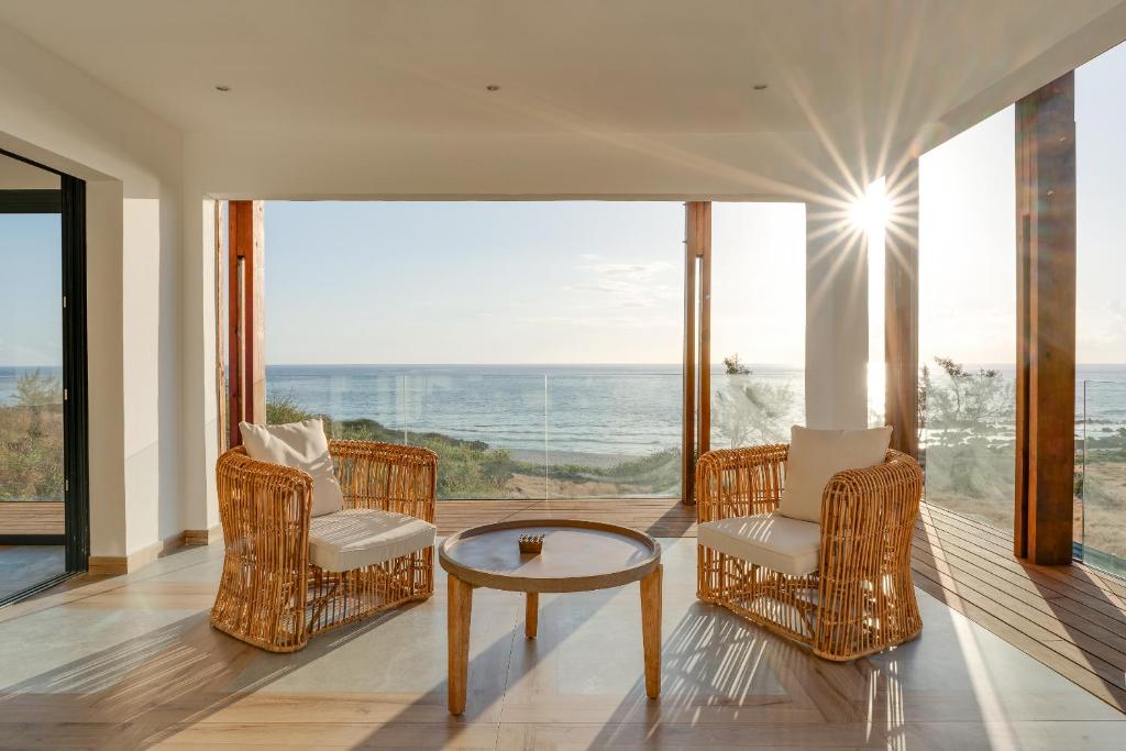 Trois BassinsにあるLe Moma by the oceanの椅子とテーブルが備わる客室で、海の景色を望めます。