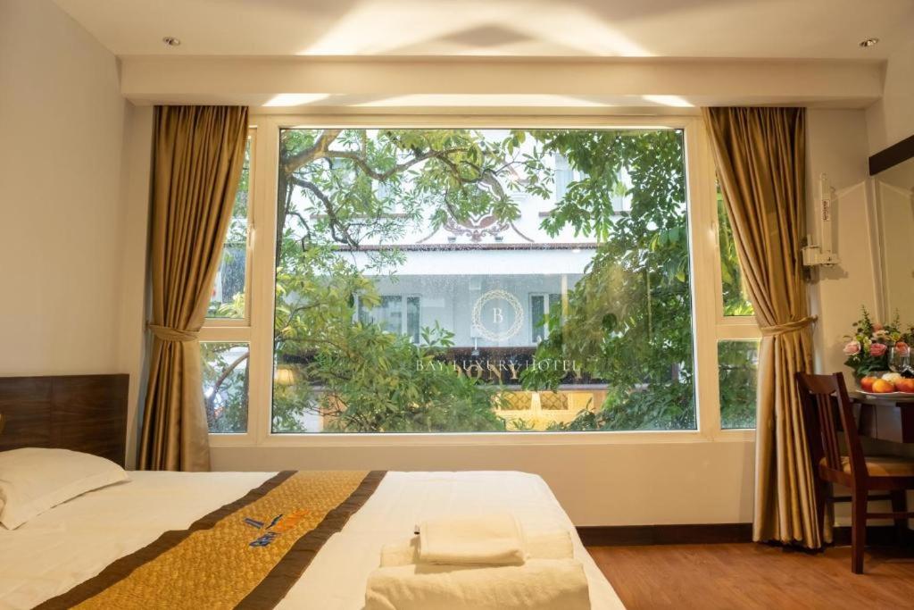 a large window in a bedroom with a bed and a table at Hotel No 9 Nguyễn Trường Tộ - by Bay Luxury in Hanoi