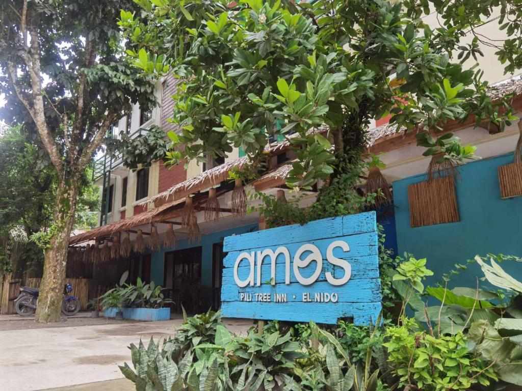 a blue sign on the side of a building at Amos Pili Tree Inn powered by Cocotel in El Nido