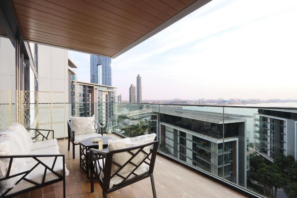 a balcony with chairs and a table on a building at Luxurious 2 BR in Bluewater w/Sea View by Livbnb in Dubai