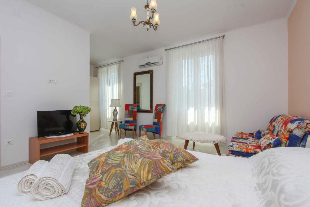 ein Schlafzimmer mit einem Bett, einem TV und einem Sofa in der Unterkunft Apartment Jasmin in Split