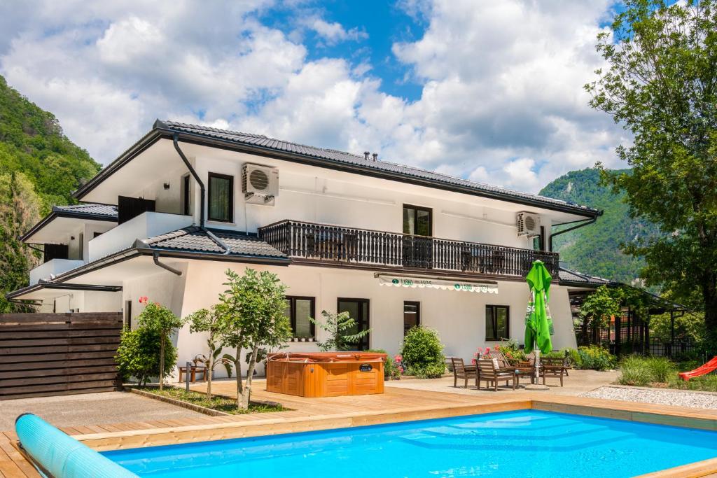 a house with a swimming pool in front of it at Penzion Šterk in Most na Soči