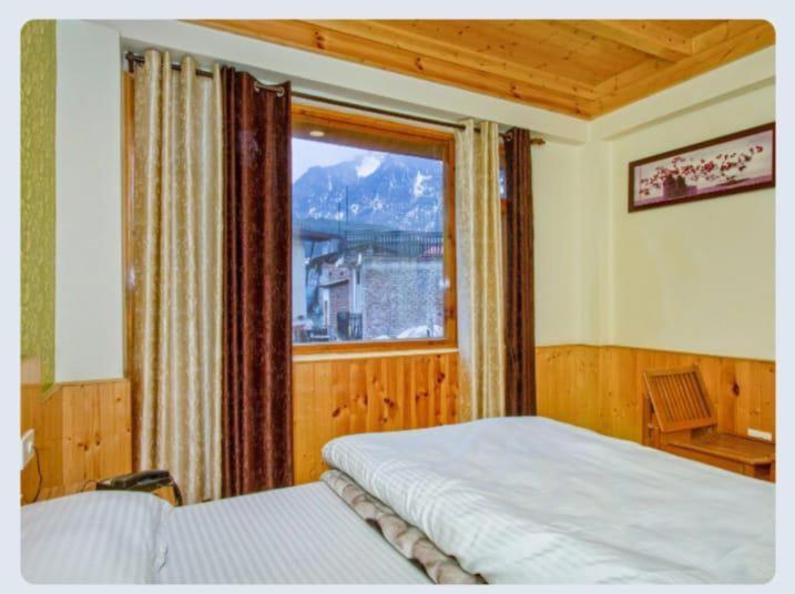馬拉里的住宿－Hotel Sun Mark，一间卧室设有一张床和一个大窗户