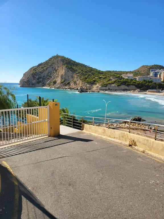 a road with a yellow gate and a view of the ocean at Europa Club Apartment, La Cala de Finestrat, Benidorm, Next to the beach, Ground floor, Air Cond in Benidorm