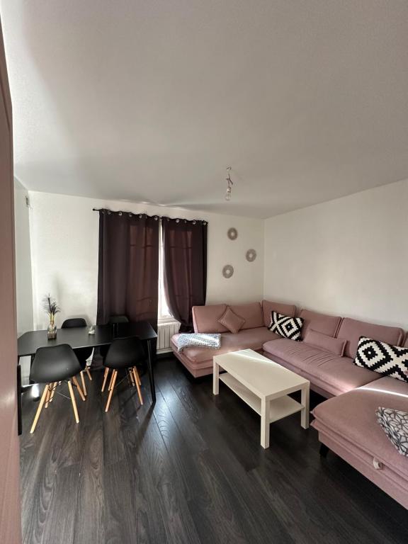 een woonkamer met een bank en een tafel bij Massi'z in Neuilly-sur-Marne
