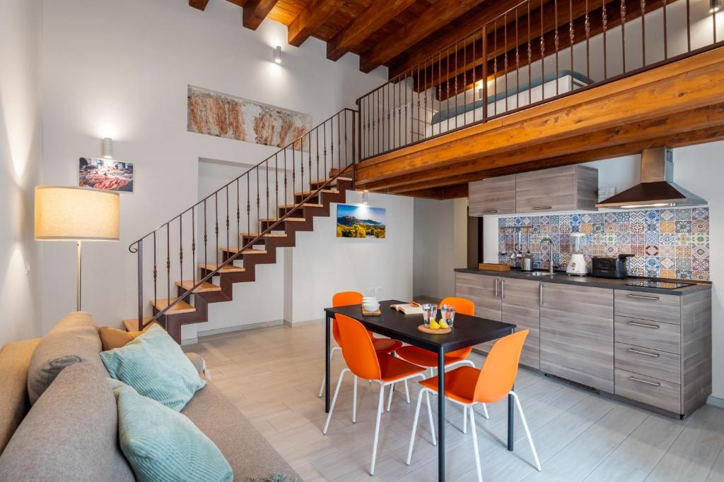 a living room with a couch and a table with orange chairs at Open Sicily Homes "Residence Guascone" - Self check in in Palermo