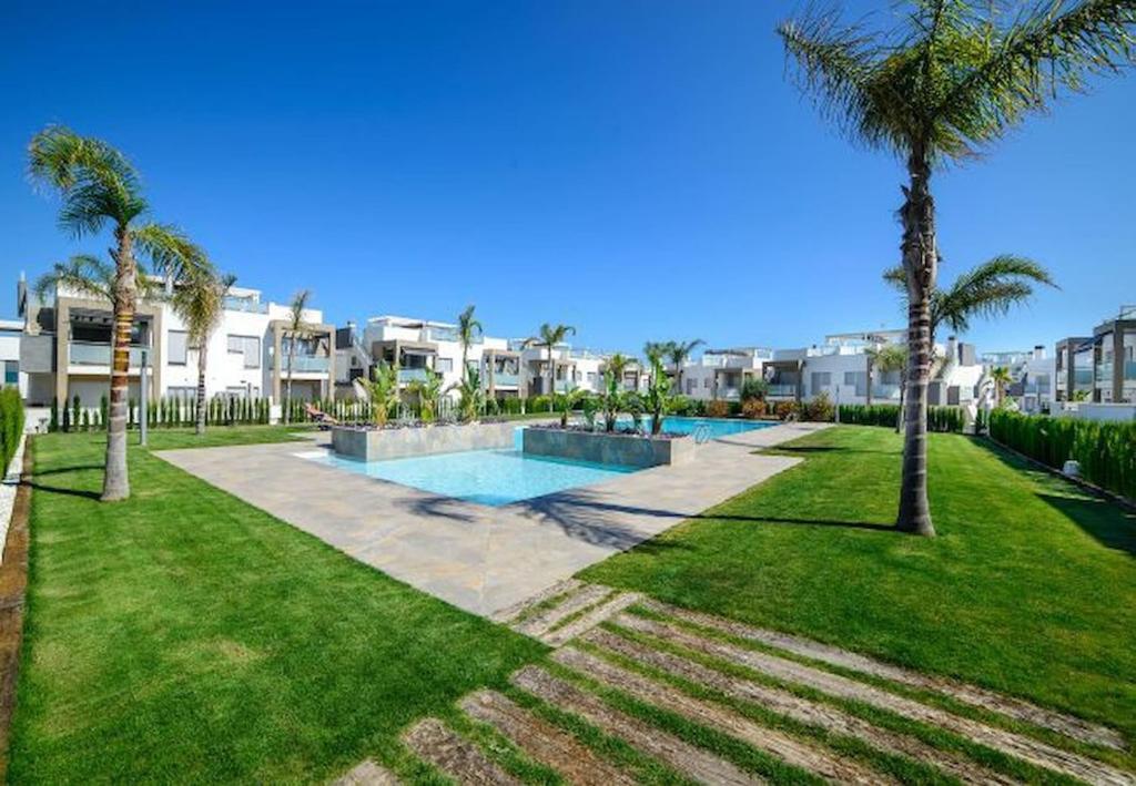 un complexe avec une piscine et des palmiers dans l'établissement Property Punta prima Amay, à Torrevieja