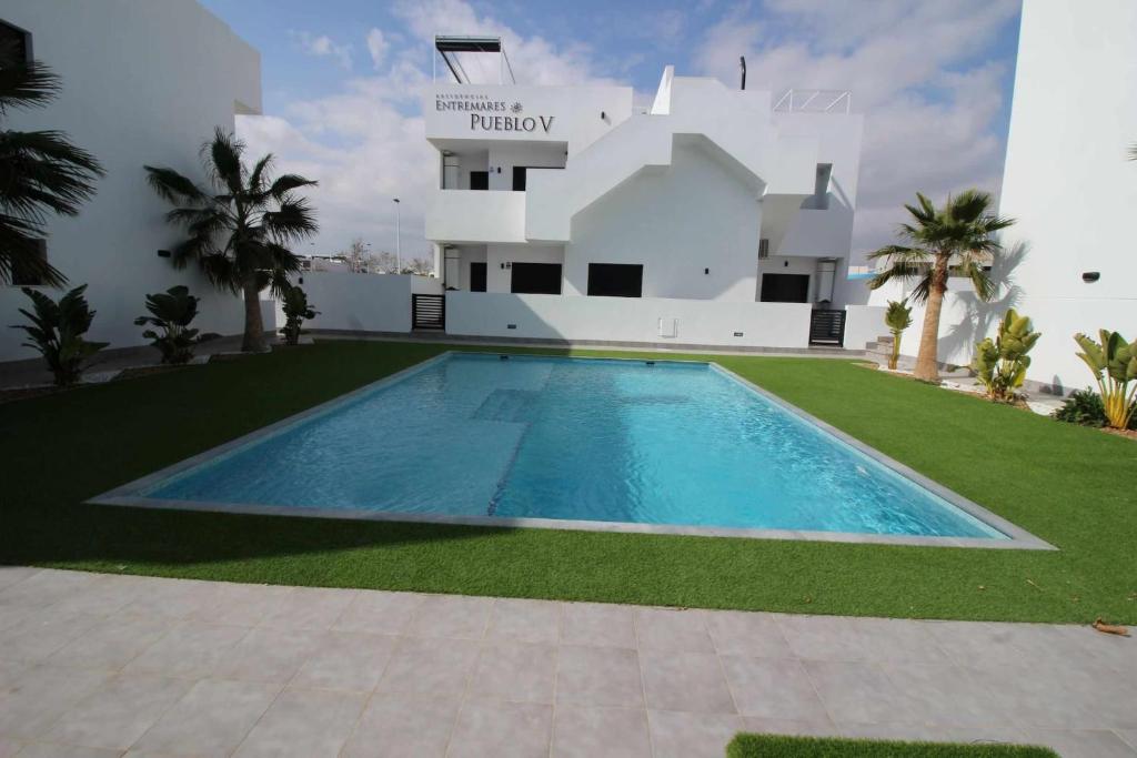 a swimming pool in front of a house at Apartamento Lopagan Entremares in Lo Pagán