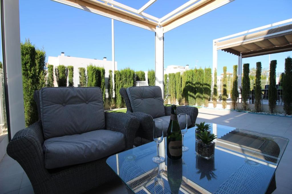 a patio with two chairs and a glass table at Vivienda aguas nuevas familiar & deportivo in Torrevieja