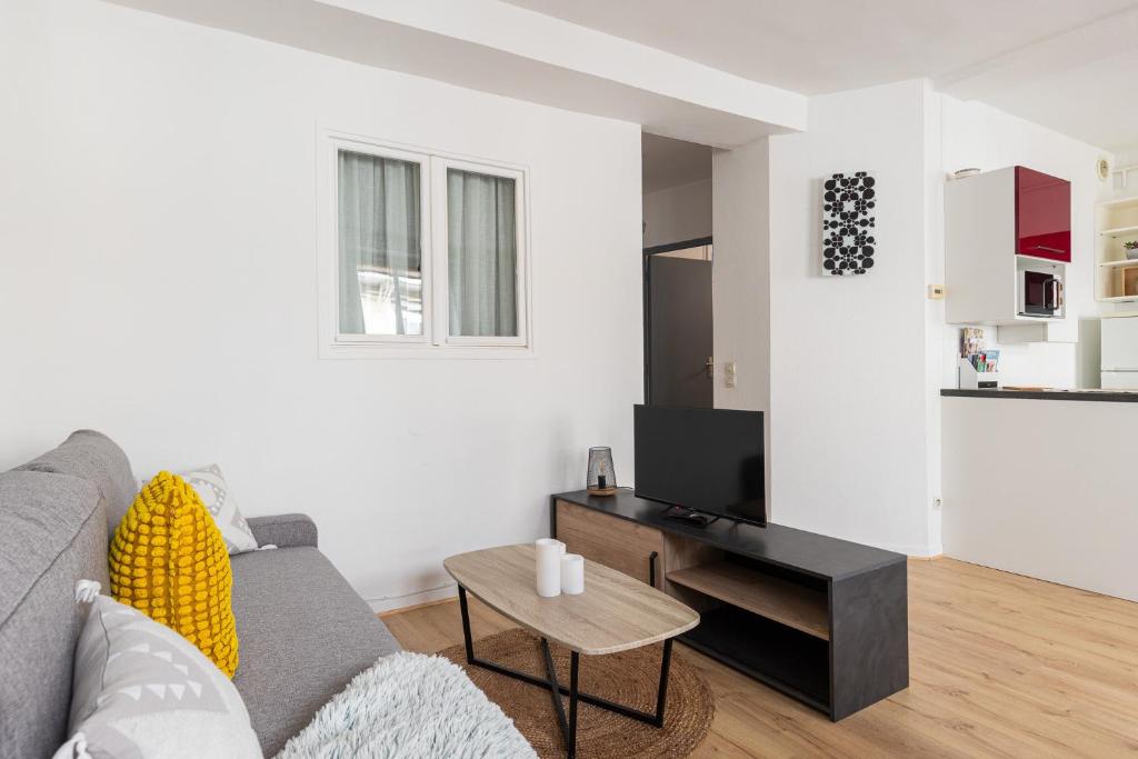 Sala de estar con sofá gris y mesa en SmartStay coeur de Vienne, en Vienne