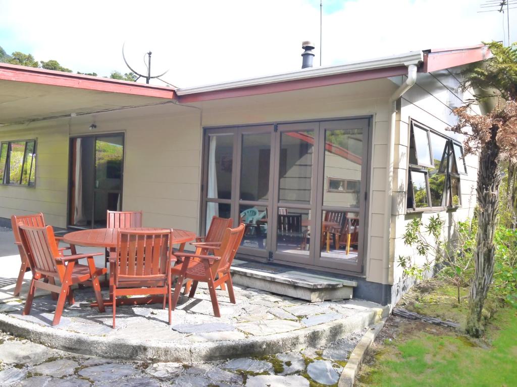 a patio with a table and chairs in front of a house at Central & Relaxing in Franz Josef