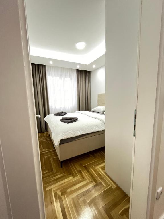 um quarto com uma cama e piso em madeira em Central Lakeview Apartment, East Sarajevo em Lukavica