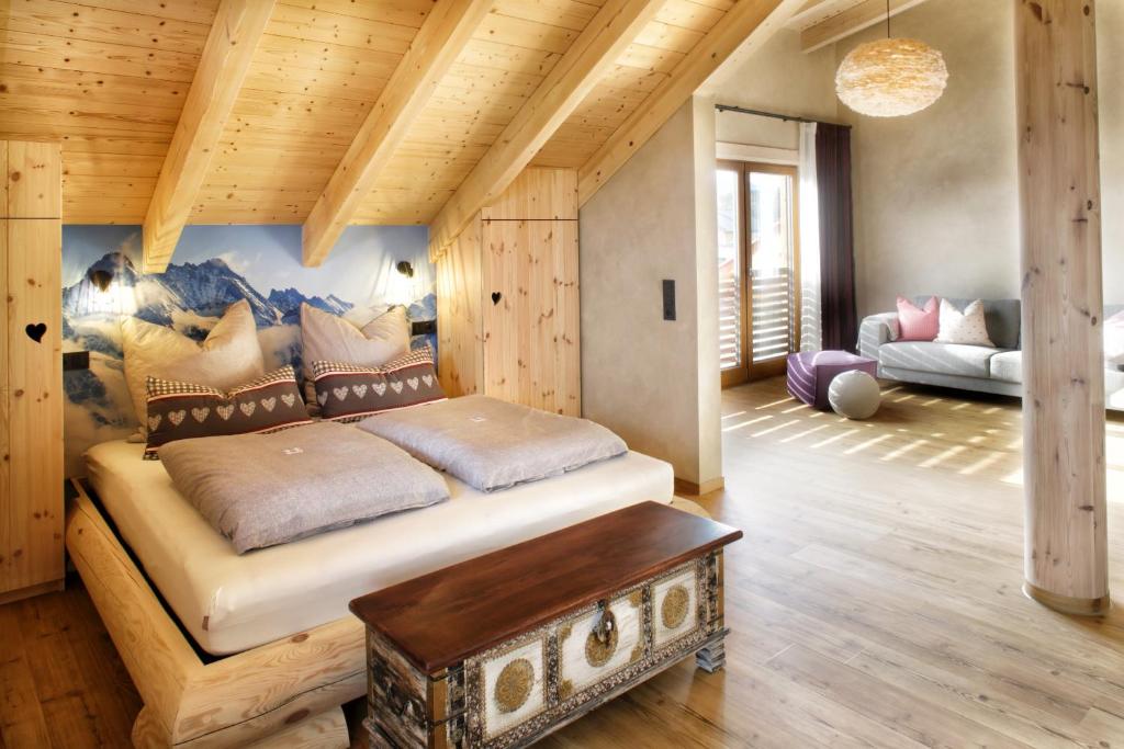 a bedroom with a large bed in a room at "Allgäu-Herzl" Alpenchalet für Zwei in Rückholz