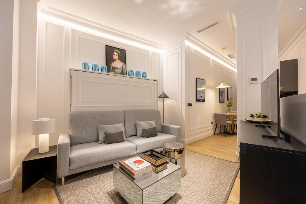 a living room with a couch and a tv at Edmond Vibes Puerta del Sol Suites in Madrid
