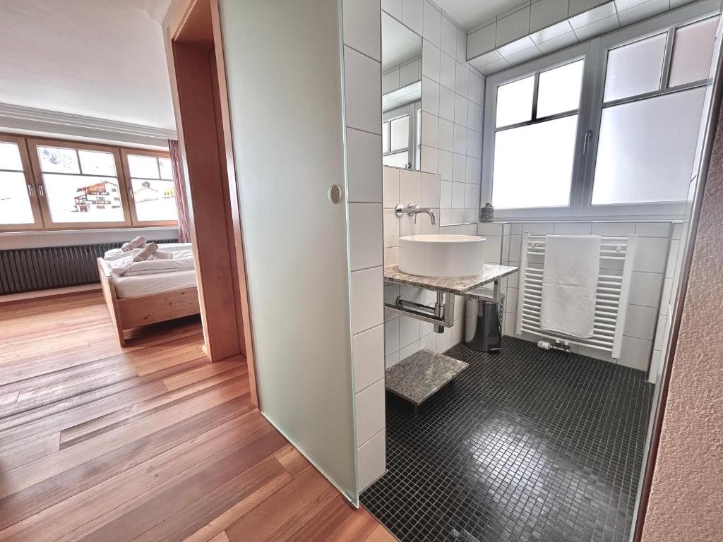 ein Bad mit einem Waschbecken und einem Spiegel in der Unterkunft Haus Wallis - Ski-In Ski-Out mit Frühstück am Arlberg in Warth am Arlberg