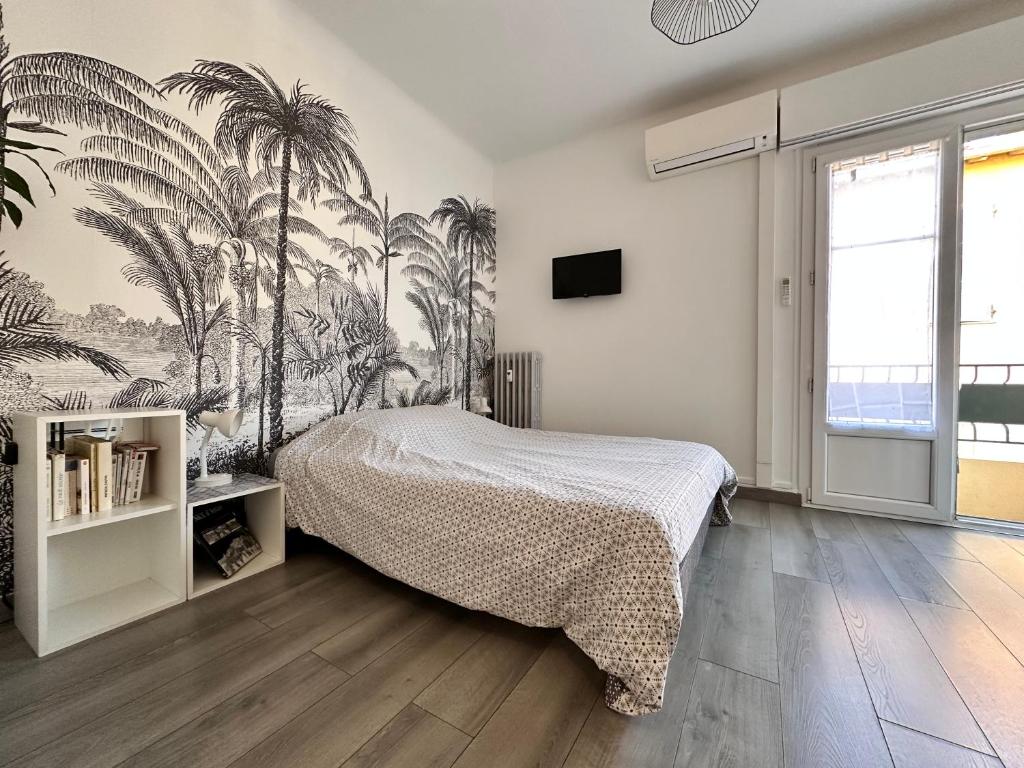 - une chambre avec un lit recouvert de palmiers dans l'établissement Studios climatisés proche mer, à Nice
