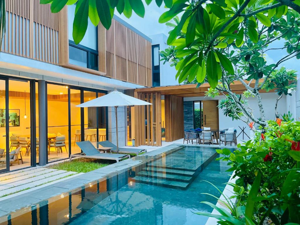 a swimming pool in a villa with a house at Moon Villa Phu Quoc - 3 Bedroom - Private pool in Phu Quoc