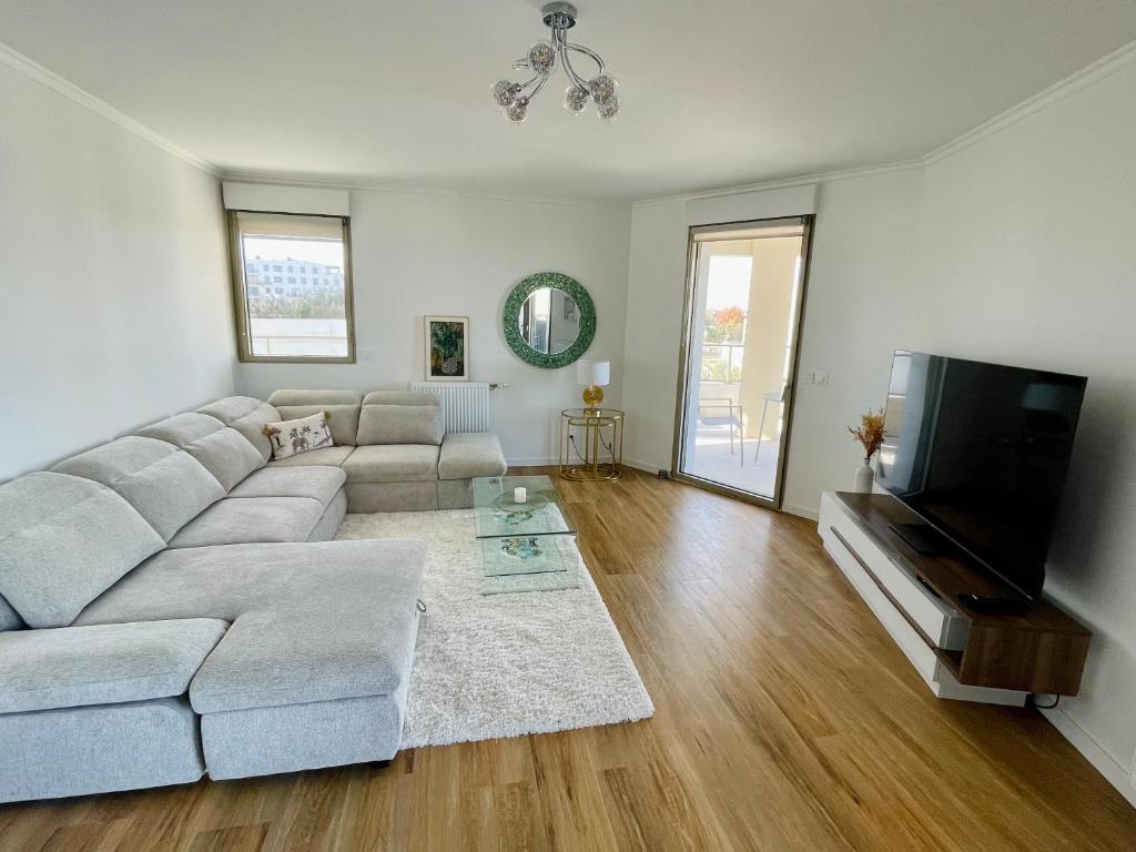 a living room with a couch and a flat screen tv at Le Raphaël - Sur les hauteurs de Bordeaux in Bordeaux