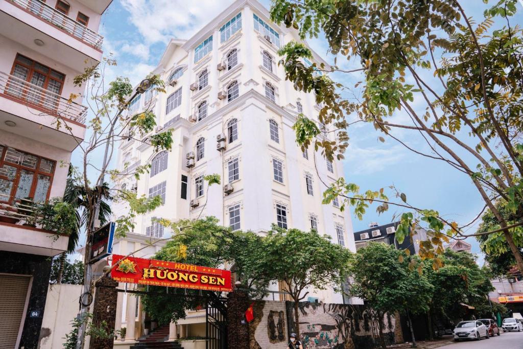 un bâtiment blanc avec un panneau devant lui dans l'établissement Hương Sen Hotel Bac Giang, à Bắc Giang