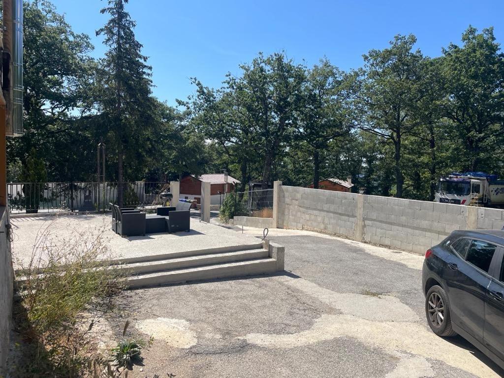un coche aparcado en un estacionamiento junto a una valla en Villa Sama’ en Roccaraso