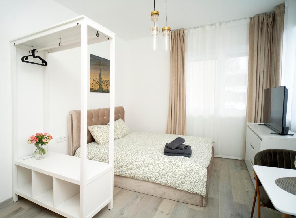ein kleines Schlafzimmer mit einem Bett und einem Spiegel in der Unterkunft Central Station Apartment No6 in Kaunas