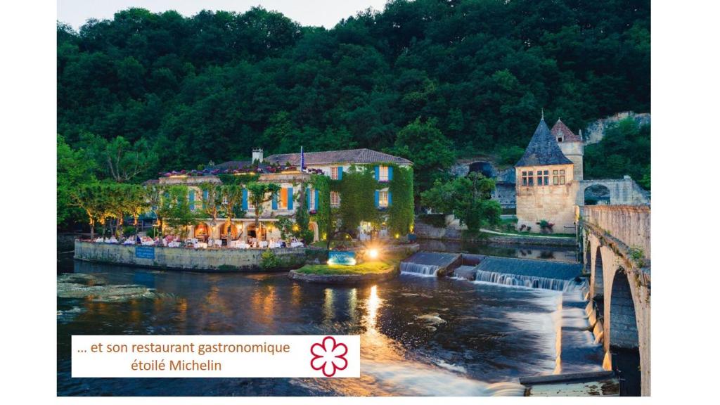 een groep mensen die rond een huis bij een rivier staan bij Moulin de l'Abbaye in Brantôme